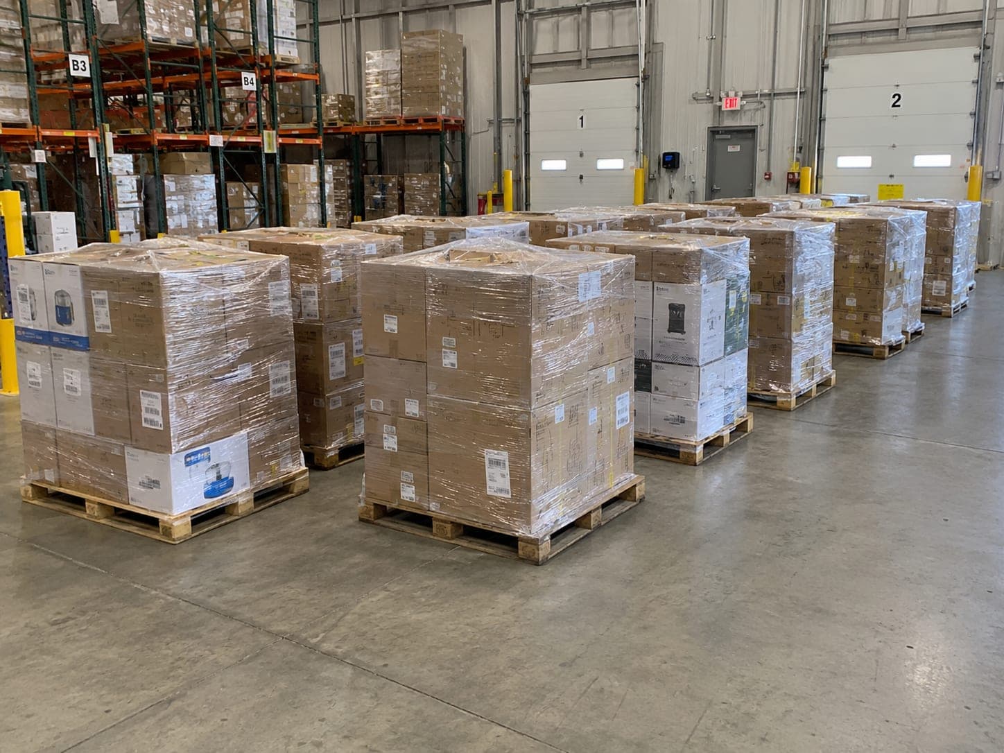 Rows of shrink-wrapped pallets staged in a warehouse for a half truckload order